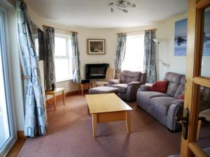 a living room with a couch and a table at SeaBreeze - Portballintrae in Portballintrae