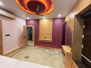 a bedroom with a purple wall and a ceiling at Govindam Palace in Govardhan +8 photos