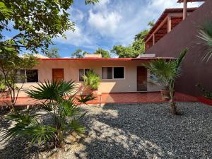 a house with palm trees in front of it at Villas victoria mirador in Zihuatanejo