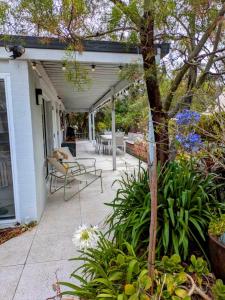a patio with tables and chairs on a house at Rye Hide Out - Rye beach retreat in Rye