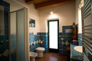 シローロにあるCampo Del Mareの青いタイル張りのバスルーム(トイレ、シンク付)