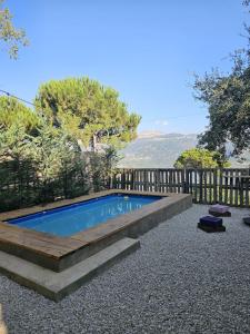 a swimming pool with a wooden bench around it at MiCastel in Ad Dawwār