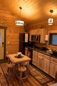 a kitchen with wooden cabinets and a table in a cabin at Sockeye Cabin - Best Views & Fishing in Seward