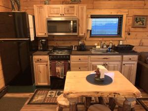 a kitchen with a table and a stove and refrigerator at Sockeye Cabin - Best Views & Fishing in Seward +18 photos