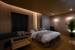 a bedroom with a bed and a couch at HOTEL MYTH-U -Adult only in Wakayama