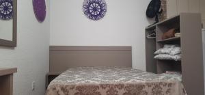 a bedroom with a bed with a bedspread on it at Recanto da Lagoa in Passo de Torres