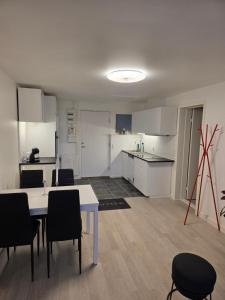 a kitchen with white cabinets and a table and chairs at 2 room apartment in Horsens in Horsens