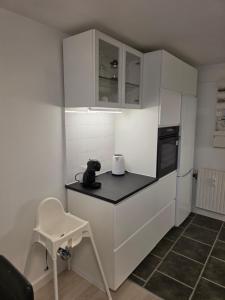 a kitchen with white cabinets and a black counter top at 2 room apartment in Horsens in Horsens +4 photos