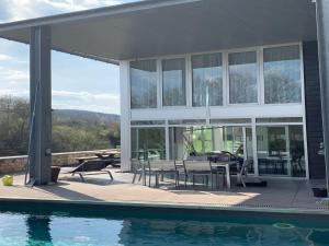 a house with a patio and a swimming pool at The Sweet Escape Premium villa with pool in Theux