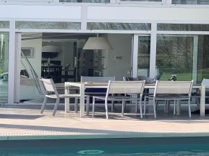 a dining table and chairs next to a swimming pool at The Sweet Escape Premium villa with pool in Theux