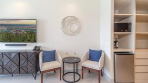 a room with two chairs and a table and a tv at Beachfront Luxury Studio in Puerto Peñasco