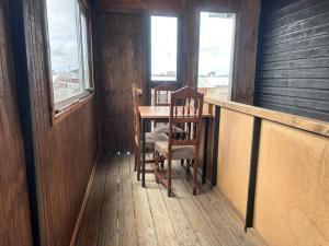 a dining room with a table and chairs and windows at Villa Lagunitas in Puerto Montt +1 photo
