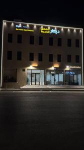 a large building with lights on it at night at ديار الاسترخاء للشقق المخدومة اقتصادي in Najran +17 photos