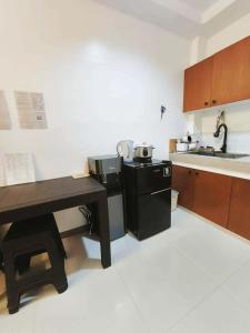 a kitchen with a black refrigerator and a sink at Marinduque Apartment in Tagum +4 photos