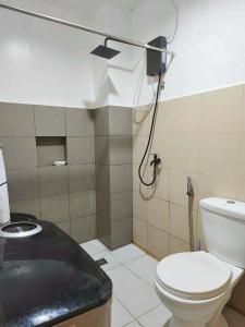a small bathroom with a toilet and a shower at Marinduque Apartment in Tagum