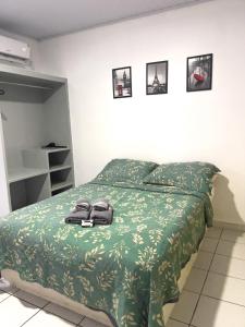 a bedroom with a bed with a green bedspread at Aparthotel holandeses in São Luís