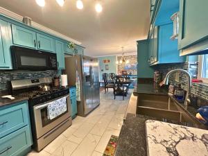 a kitchen with blue cabinets and a stove top oven at Lake House in Phil Campbell