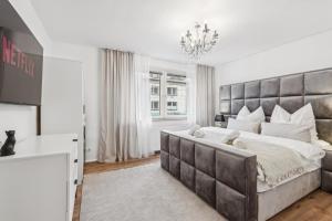 a bedroom with a large bed and a chandelier at Design-Apartment in Rüttenscheid, Kulturlage & Top-Anbindung in Essen