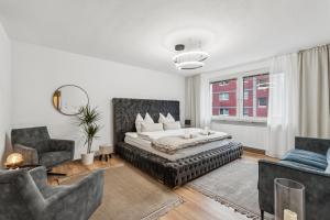 a bedroom with a bed and a couch and chairs at Design-Apartment in Rüttenscheid, Kulturlage & Top-Anbindung in Essen