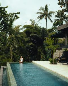 a woman sitting in a swimming pool at a resort at Samanvaya - Adults Only in Sidemen