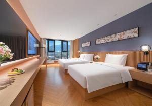 a hotel room with two beds and a desk at Orange Crystal Hotel Dali Erhai Park in Dali +30 photos