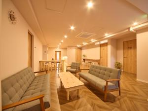 a hospital room with couches and a table and chairs at Southern Gate HIVE in Ishigaki Island