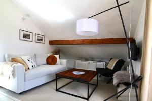 a living room with a white couch and a table at Les Cimes - Le Tholy in Le Tholy