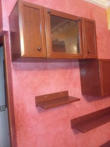 a kitchen with wooden cabinets on a pink wall at Tetuan in Tétouan