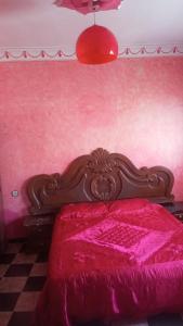 a bedroom with a red bed with a wooden headboard at Tetuan in Tétouan