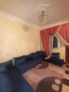 a living room with a blue couch and red curtains at Tetuan in Tétouan