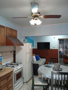 a kitchen with a white refrigerator and a table at Mistela Altos Crucero Boutique - Alojamiento temático - Zona Residencial Ciudad - Viajes al Aeropuerto - in Godoy Cruz
