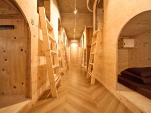 a room with wooden walls and a hallway with shelves at Southern Gate HIVE in Ishigaki Island