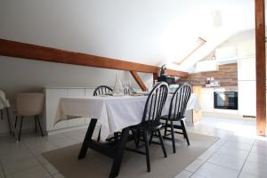 a dining room with a white table and chairs at Les Cimes - Le Tholy in Le Tholy