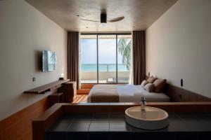 a bedroom with a bed and a sink and a window at Meraki Oasis Hotel in Mui Ne +77 photos