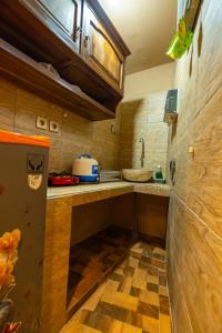 a kitchen with a sink and a refrigerator at Sajjana House Nusadua By Magno in Nusa Dua