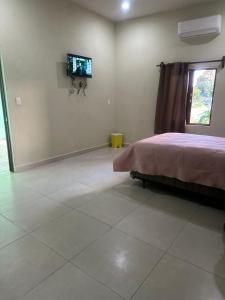 a bedroom with a bed and a tv on the wall at Casa mahana in Pisté