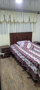 a bedroom with a bed with a quilt on it at Apto con balcon in Pasto