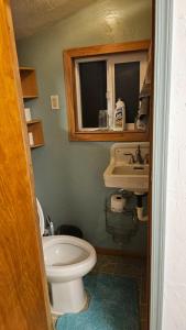 a bathroom with a toilet and a sink and a window at Gerardín in Flagstaff