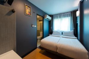 a bedroom with a bed with a window and a toilet at BB House Phra Athit บีบี เฮ้าส์ พระอาทิตย์ in Bangkok +3 photos
