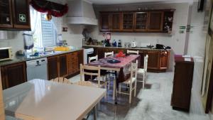 a kitchen with a table and chairs in it at Room 2 - Music House in Bicas +2 photos