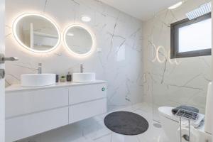 a white bathroom with two sinks and a mirror at Luna do Mar - Luxury apt with Jacuzzi in Gaula +46 photos