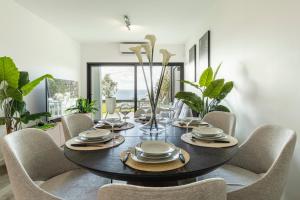 a dining room with a black table and chairs at Luna do Mar - Luxury apt with Jacuzzi in Gaula