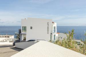 a white building with the ocean in the background at Luna do Mar - Luxury apt with Jacuzzi in Gaula