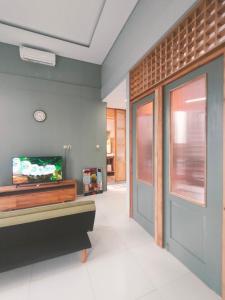 a living room with a tv and a door at The Sawa Stay in Jarakan