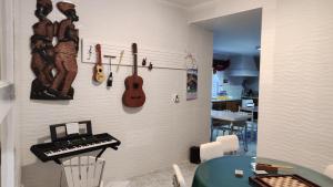 a room with a wall with guitars and a keyboard at Room 2 - Music House in Bicas