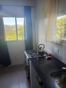 a kitchen with a stove and a tea kettle on the counter at Wandritu in Río Ceballos