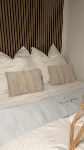 a bed with white sheets and pillows on it at Zentrale Gästezimmer am Marienplatz- Paris in Stuttgart