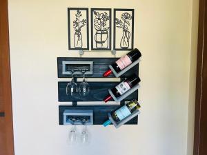 a wall mounted wine rack with wine bottles and glasses at Pousada Reserva Verde com piscina privada com vista para a serra Studio térreo in Quatro Barras