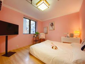 a bedroom with a bed with a teddy bear on it at 上海Zighouse人民广场店 People's Square Branch, Shanghai in Shanghai
