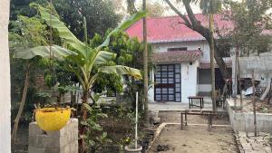 a garden with a banana tree and a house at Pushpa Nilayam in Khaprail